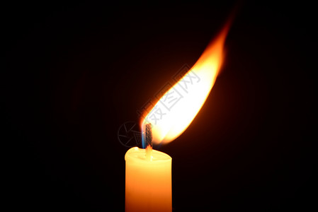 白蜡烛火焰黑色背景的白蜡烛燃烧假期烧伤火焰黄色白色纪念馆温泉场景宗教宏观背景