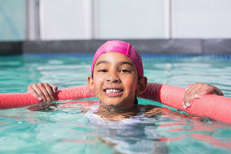 可爱的小孩在游泳池游泳水池童年闲暇游泳衣微笑活动中心女性泡沫运动背景图片