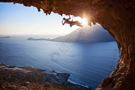 海卫一日落时男性攀岩者活动挑战悬崖成人岩石天空运动太阳风景男人背景
