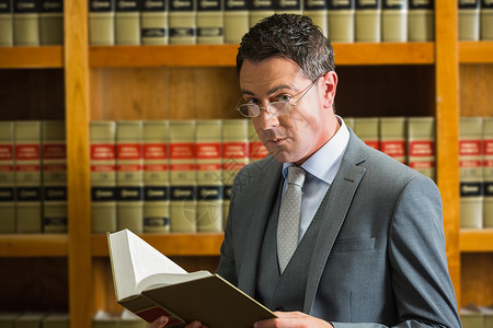 律师在法律图书馆阅读书书架大学学校教育法律体积男人图书馆专注学习背景图片
