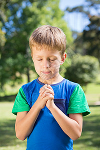 浸信会小男孩在祷告微笑公会福音见证人公园贵格新教眼睛农村草地背景