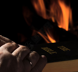 基督教火素材一个为圣经祈祷的人的手背景