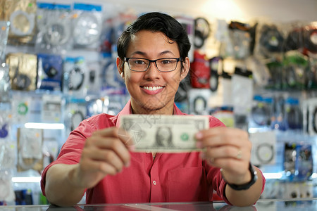 快乐的中国男人在个人电脑商店展示一元收入背景图片