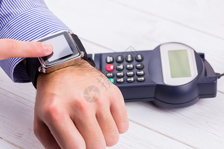 使用智能手表表示工资的人信用卡电子商务银行业支付活动钱包芯片近场销售点电子背景图片
