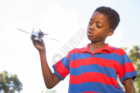 玩玩具飞机的小男孩儿微笑男生快乐绿地晴天公园绿色男性农村飞行背景