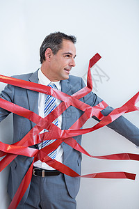 商务人士被繁琐的手续困住夹克挑战公司边界套装红色领带官僚商业磁带背景图片
