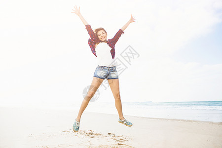 享受生活女性微笑跳跃女孩黑发海滩女士旅行情感青少年背景图片