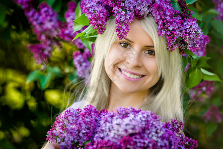 紫色美丽花环紧贴近身的肖像 美丽的笑着微笑的年轻女士 穿着花环背景