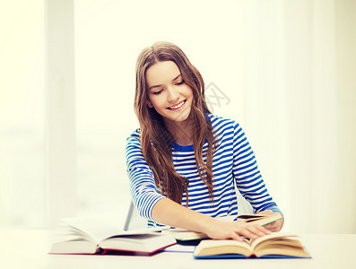 带着书籍的快乐笑笑着女学生微笑百科图书青少年测试叶子会议大学学者桌子背景图片