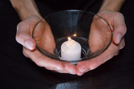 手握蜡烛火焰双手黑暗信仰阴影祷告黑色背景背景图片