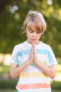 小男孩在祷告草地晴天男性闲暇公会眼睛童年天主教徒见证人浸信会背景