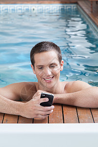 男人游泳人在游泳池里玩细胞游戏温泉乐趣男性微笑手机假期游泳蓝色财产屏幕背景