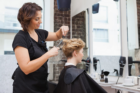 拉直头发理发师给顾客打发头发美发快乐沙龙理发女士商务发型工作女性造型师背景