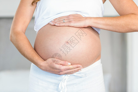 持有腹部的妇女的中产妇女高清图片