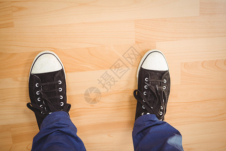 身穿帆布鞋的商务人士站在硬木地板上高清图片