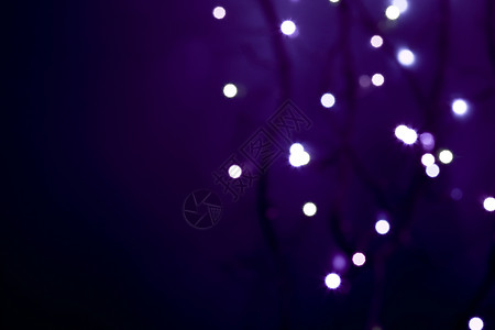 暗紫色背景上的白色非焦点灯光背景图片