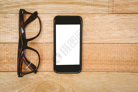 眼镜和智能手机视图技术白色触摸屏桌子屏幕电话时尚木头背景图片