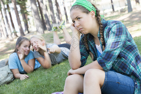 女孩闲聊女性头发欺凌树木女孩们青少年压力公园孤独孩子背景图片