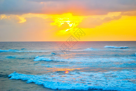 海岸的日落悬崖假期橙子蓝色天空旅行白色海滩太阳海洋高清图片