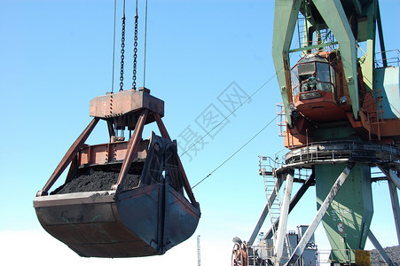 装货物码头起重机在Kolyma河港装煤工业驳船钢包运输职业避风港矿物金属工作煤炭背景