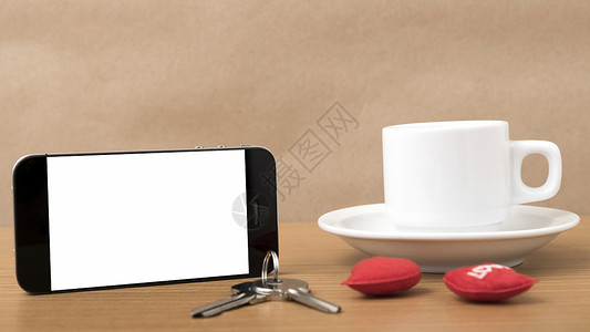 咖啡电话钥匙和心脏白色红色杯子手机办公室桌子礼物木头背景图片