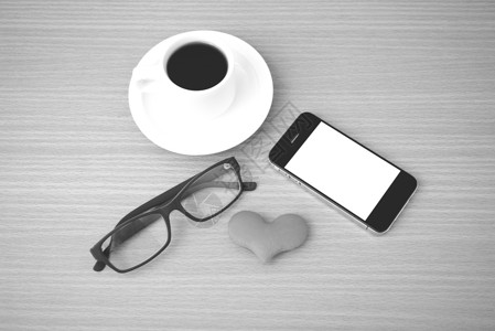 咖啡 电话 眼镜和心脏手机杯子办公室木头桌子白色红色背景图片