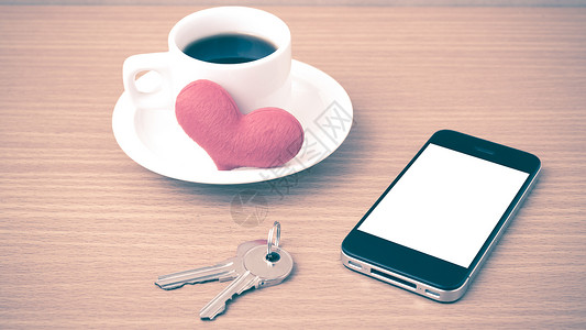 咖啡电话钥匙和心脏木头杯子礼物白色桌子办公室手机红色背景图片