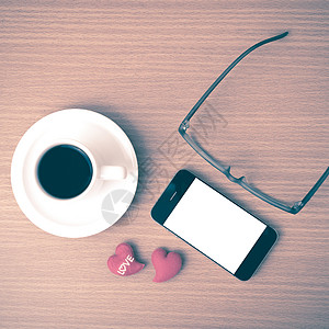 咖啡 电话 眼镜和心脏办公室手机白色杯子桌子红色木头背景图片