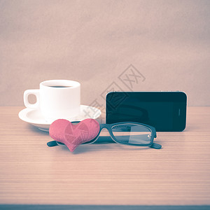 咖啡 电话 眼镜和心脏木头红色办公室白色手机杯子桌子背景图片
