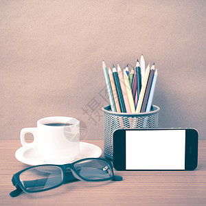 咖啡 电话 眼镜和铅笔办公室杯子手机职场技术日记记事本桌子商业背景图片