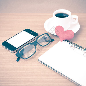 咖啡 电话 眼镜 笔记和心脏手机杯子桌子办公室红色背景图片