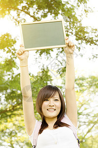 亚洲大学生女学生 带空白黑纸板背景图片