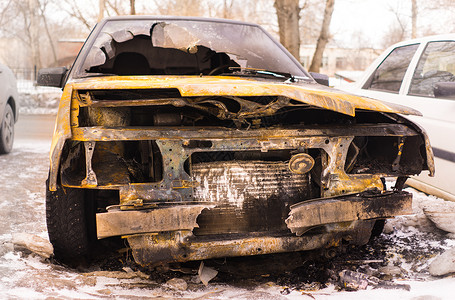 故意纵火后焚烧的汽车弯曲机身体倾倒挡泥板车祸保险碎片残骸车辆运输背景