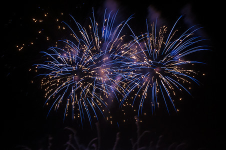 夜空中的蓝烟花黑色周年假期橙子星星天空白色派对庆典新年背景图片