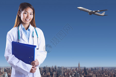 持有蓝色装饰器的亚洲医生综合图像蓝天女性城市建筑绘图航班航空实习生摩天大楼商业背景图片