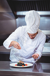 主厨在菜盘上喷洒香料餐厅美食厨师男人职业食物烹饪厨房制服盘子背景图片