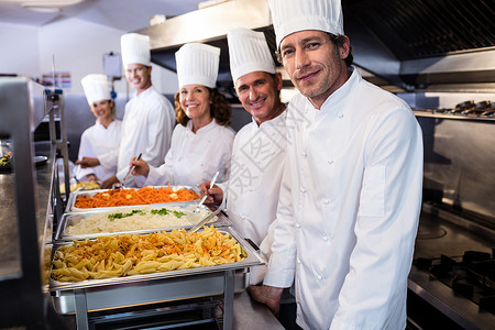 自助餐50元站在意大利面托盘上供餐的厨师职员团队自助餐快乐女士钢包面条工人营养碳水背景