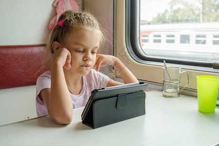 女孩看着火车上的平板电脑高清图片