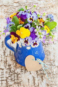 春花的一束鲜花标签花朵陶瓷乡村植物群缠绕桦木蓝色制品花瓶背景图片