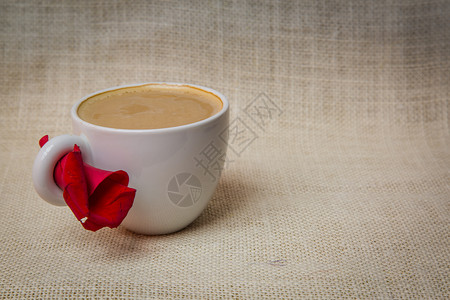 清晨一小杯加玫瑰花瓣的咖啡红色玫瑰花瓣喝咖啡背景图片