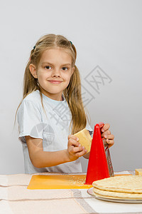 6岁女孩在厨房桌前摆着起司和磨毛机成人食物孩子桌子食谱糕点学习母亲帮助孩子们背景图片