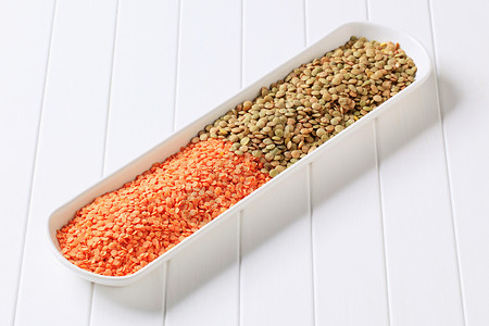 生红色和棕色扁豆椭圆形盘子豆子红色白色营养食物橙子种子豆类背景图片