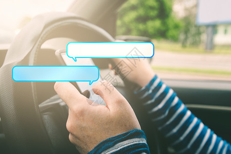 车框女性驾驶汽车和用语音泡沫在智能手机上发短信背景