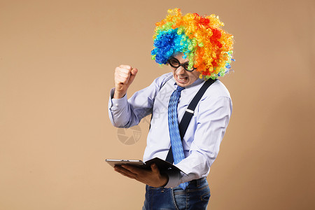 小丑拳头假戴小丑假假发的商务人士用平板电脑进入T吊带裤孩子们衬衫笑声商业工作手势压力眼镜生意人背景