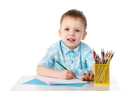 勤勉的微笑的小男孩用蜡笔画画注意力艺术教育男性孩子青少年好奇心知识艺术家铅笔背景