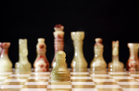 棋盘上的象棋片工艺头脑竞赛商业象棋运动玛瑙国王对抗棋子背景图片