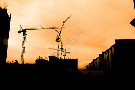 脚手架建筑工人团体活动男人劳动工作日落头盔建造锤子工业背景图片