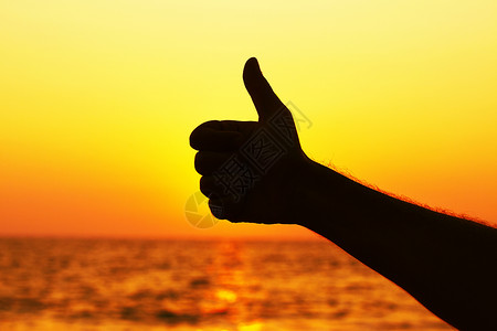 喜怒缩略图上手势日落拇指太阳假期天空男人标志优胜者手指背景