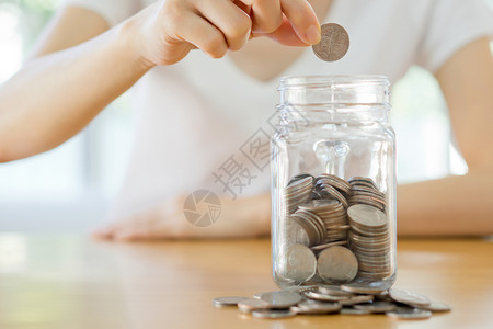 乌克兰语女人手在玻璃罐里拿着硬币 关上金融收藏金子账单工作商业玻璃繁荣女士财富背景