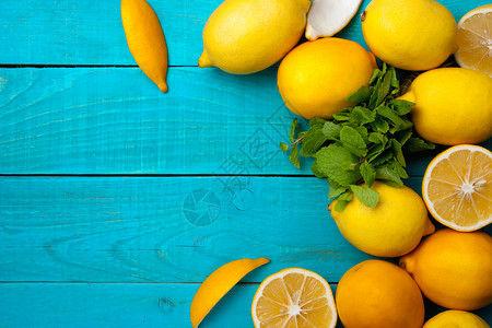 柠檬水果边框亮青色背景的柠檬边框蓝色木头水果黄色食物香橼薄荷热带桌子木板背景